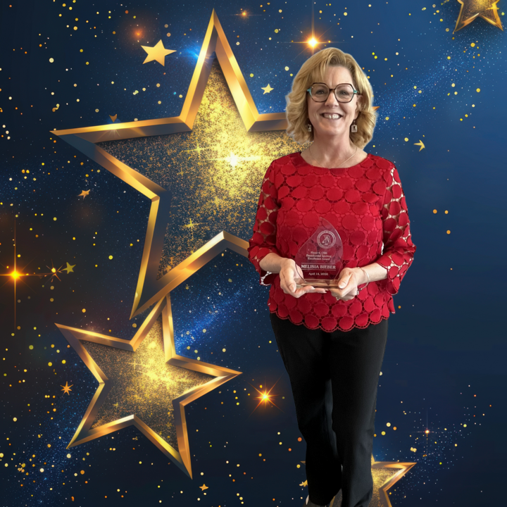 Woman in a red top holding a clear award against a sparkling starry backdrop.
